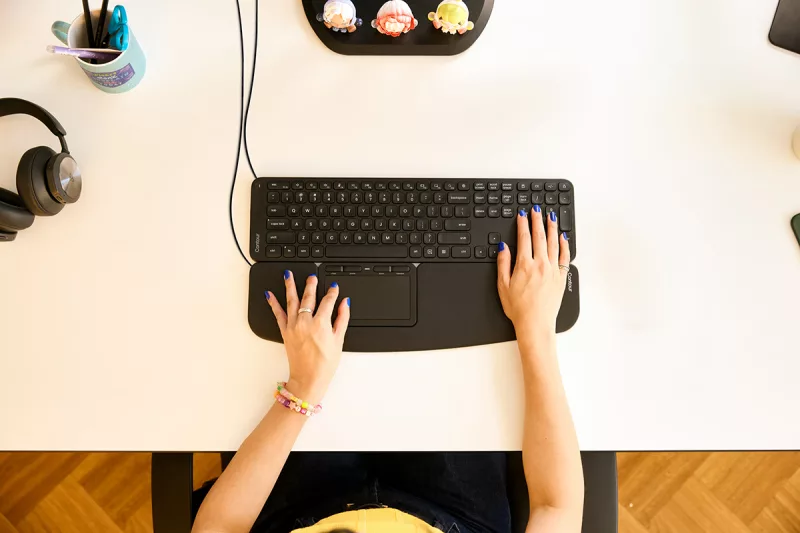 Support de PC portable Contour Laptop Riser utilisé avec clavier et souris intégrés, vue en situation de travail