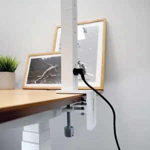 Lampadaire Silvar fixé par pince sur un bureau avec système de serrage et alimentation électrique.