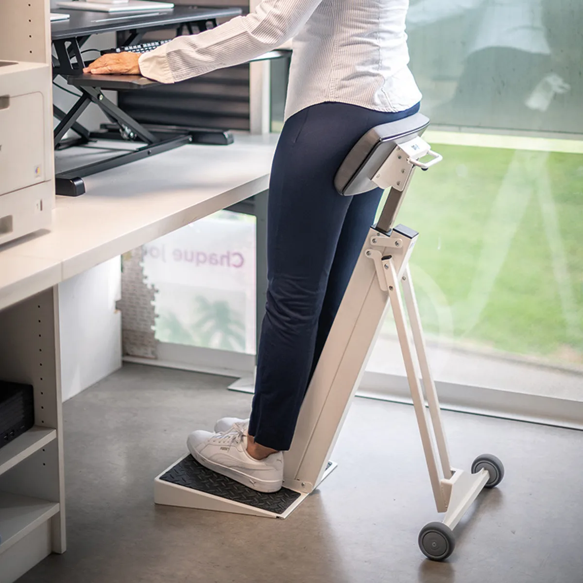 c61ad41eefd3fdabdea546e7511c64052833bc67_Appui_debout_AMUP_situation_RVB_72_dpi.jpg Appui-debout ergonomique AMUP en situation réelle, avec appui dorsal, structure escamotable sur roulettes et plateforme antidérapante