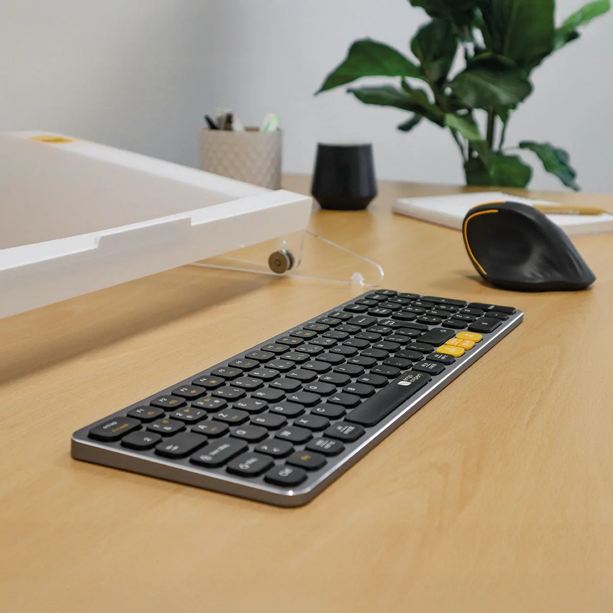 Clavier ergonomique X-Per multi-connexions standard posé sur un bureau en bois, accompagné d'une souris verticale ergonomique et d'un support de documents